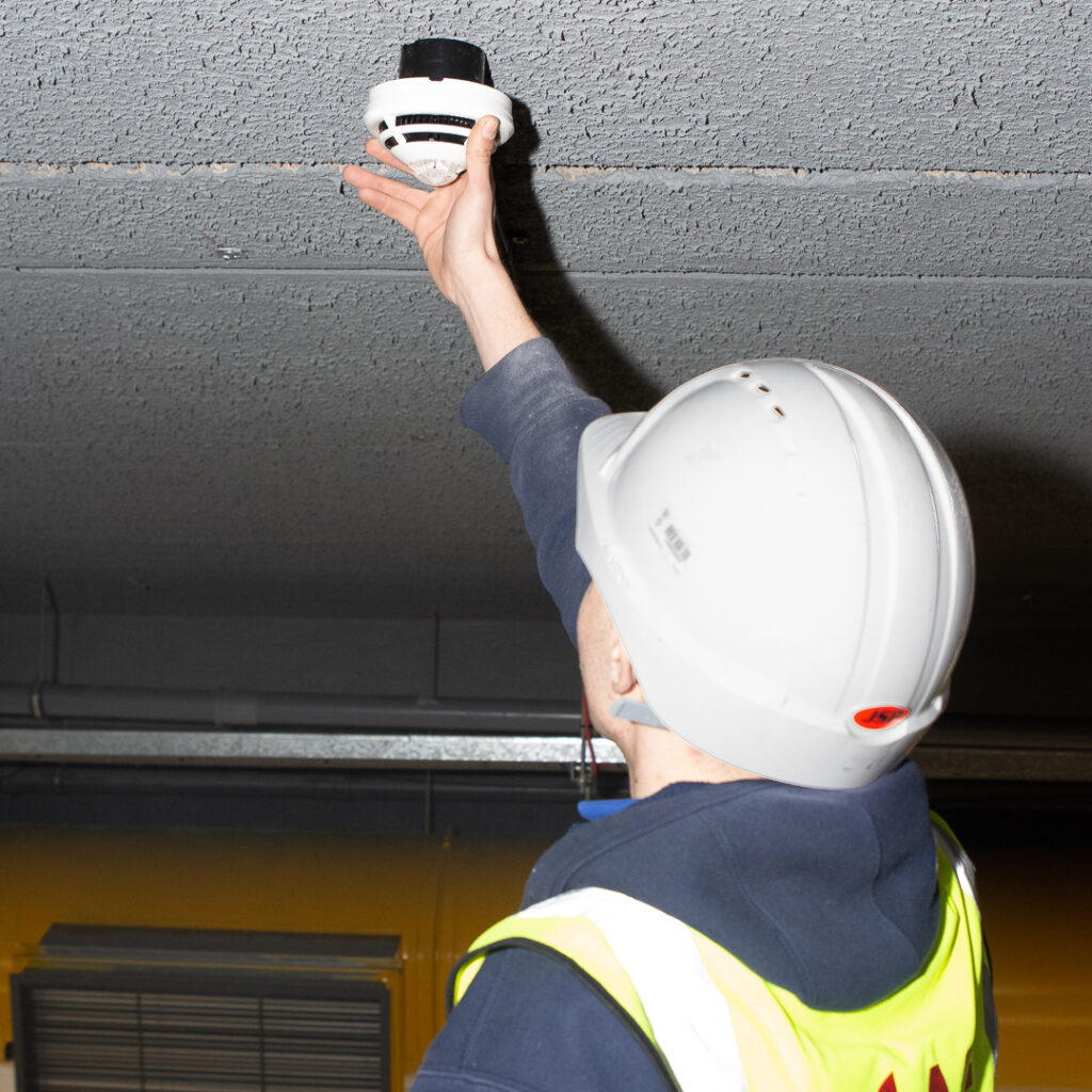 Engineer installing smoke detector