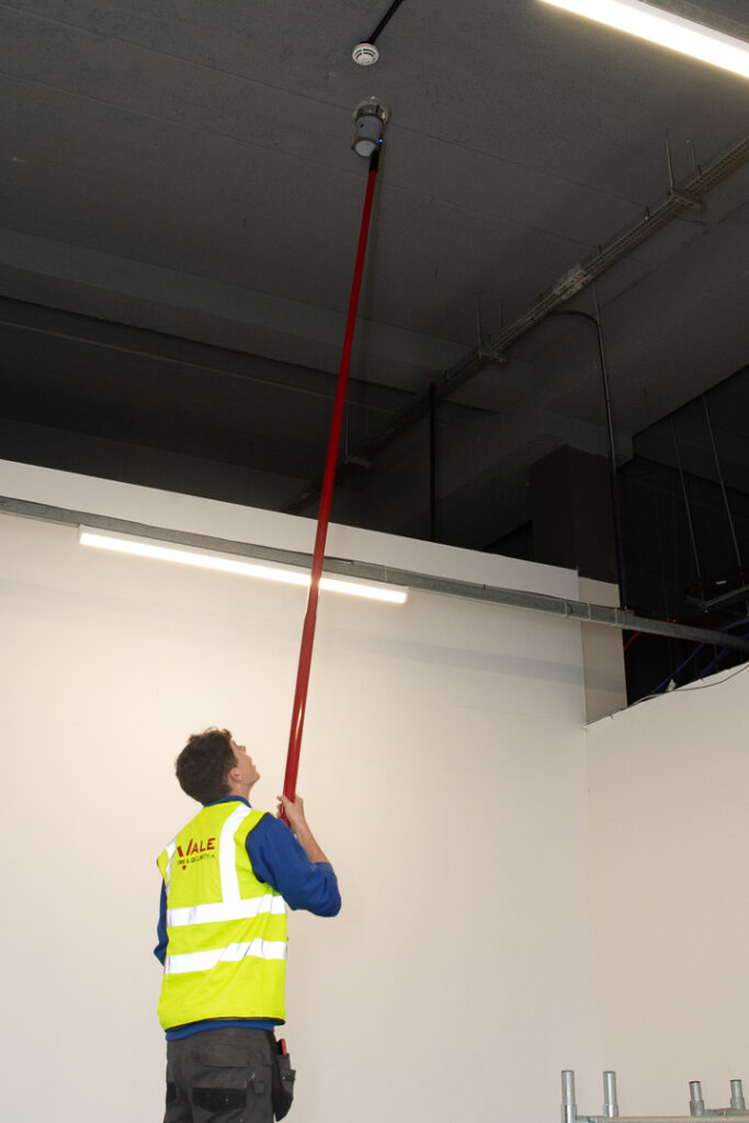 Engineer testing domestic fire alarm
